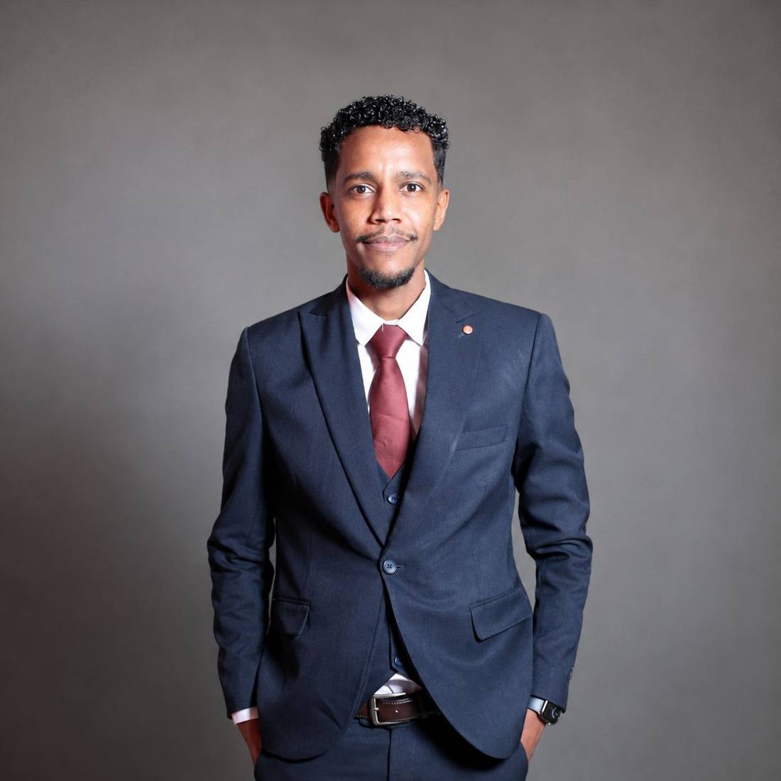 Portrait of Khalid Korena in a navy three-piece suit